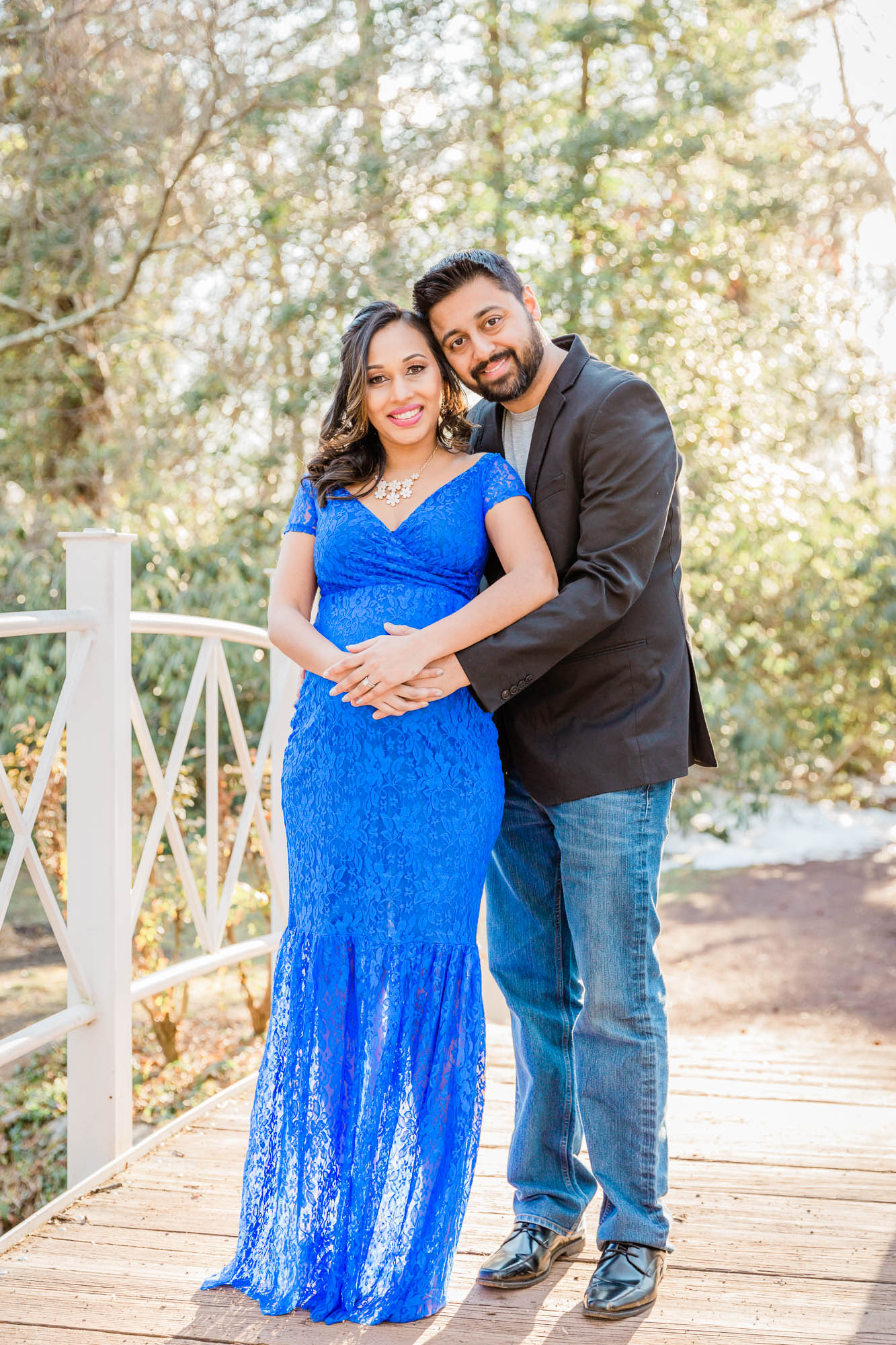parents to be posing on bridge for maternity portrait